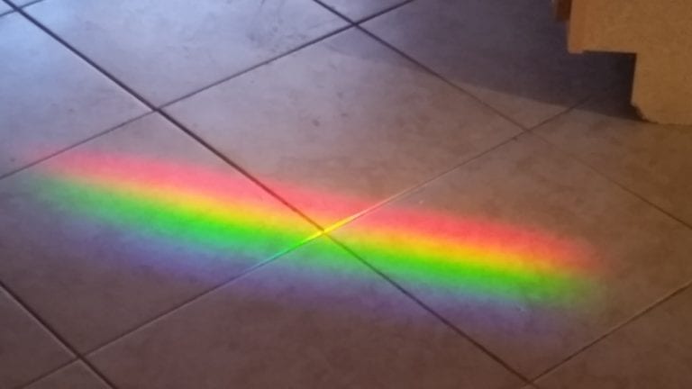 Image of a rainbow across a tile floor