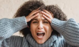 Image of a mom screaming and holding her head. 