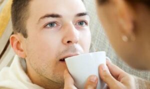 Image of female holding a cup of water up to a males mouth