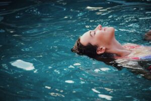 Image of woman floating in water with eyes closed.